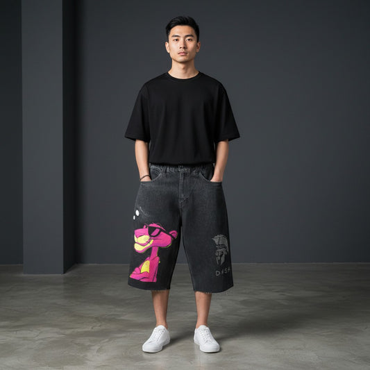 CN Urban black denim shorts with pink panther graphic print and distressed hem. Relaxed fit.
