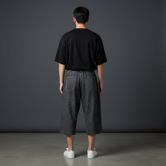 CN Urban black oversized t-shirt and grey wide-leg denim culottes with eyelet embellishments and raw hem.